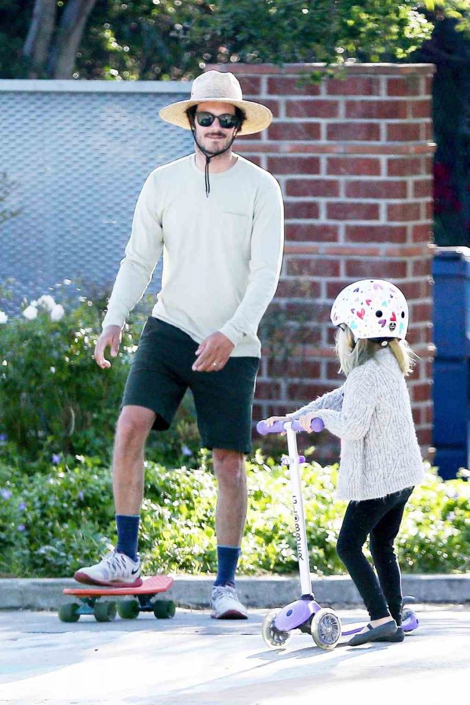 A photo of Adam Brody with daughter Arlo Day Brody, skateboarding.
